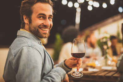 Young man holding wineglass