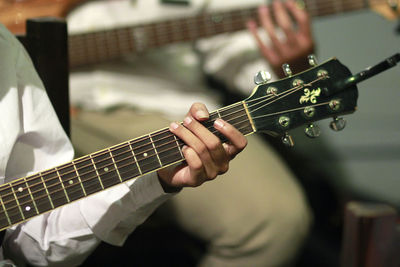 Midsection of man playing guitar