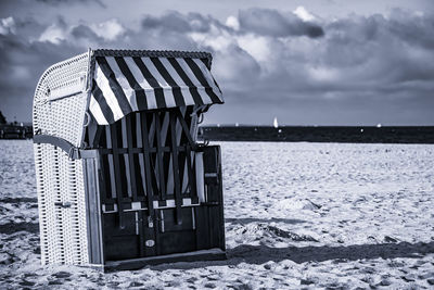 Built structure on land by sea against sky