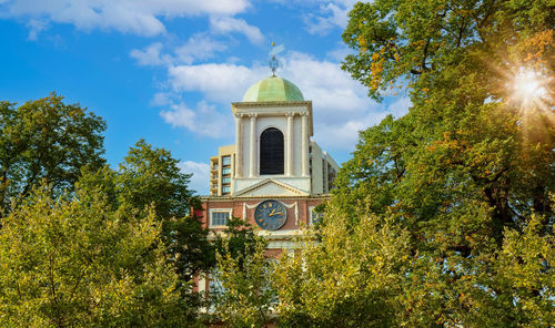 Low angle view of trees and building against sky