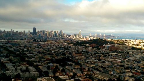 Cityscape against cloudy sky