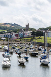 Boats moored on sea against sky in city