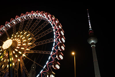 Low angle view of illuminated ferris wheel at night