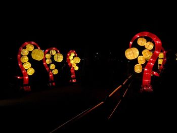 Illuminated lanterns against sky at night