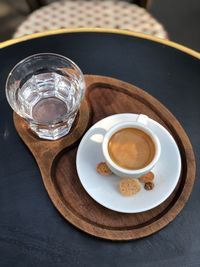 High angle view of coffee and water in wooden tray on table