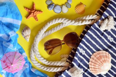 Directly above shot of seashells and personal accessories on table