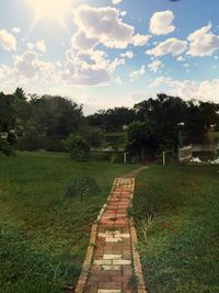 Scenic view of grassy field against cloudy sky