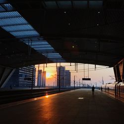 Railroad station platform in city during sunset
