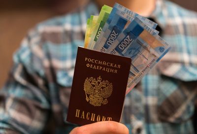 Midsection of man holding money and passport