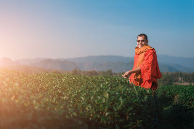 Man standing on field against sky during sunset