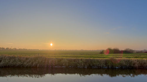 Scenic view of field against sky during sunset