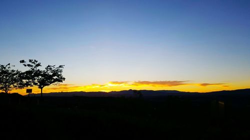 Silhouette of landscape against sky at sunset