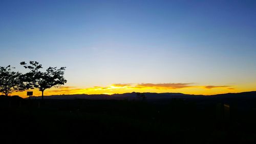 Silhouette of landscape against sky at sunset