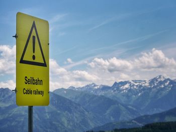 Information sign against mountains and sky