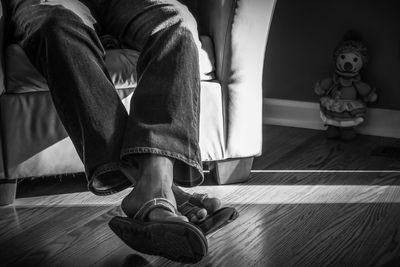 Low section of man sitting on chair at home