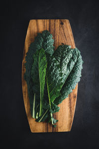 Cavolo nero black curly kale vegetable on wooden board