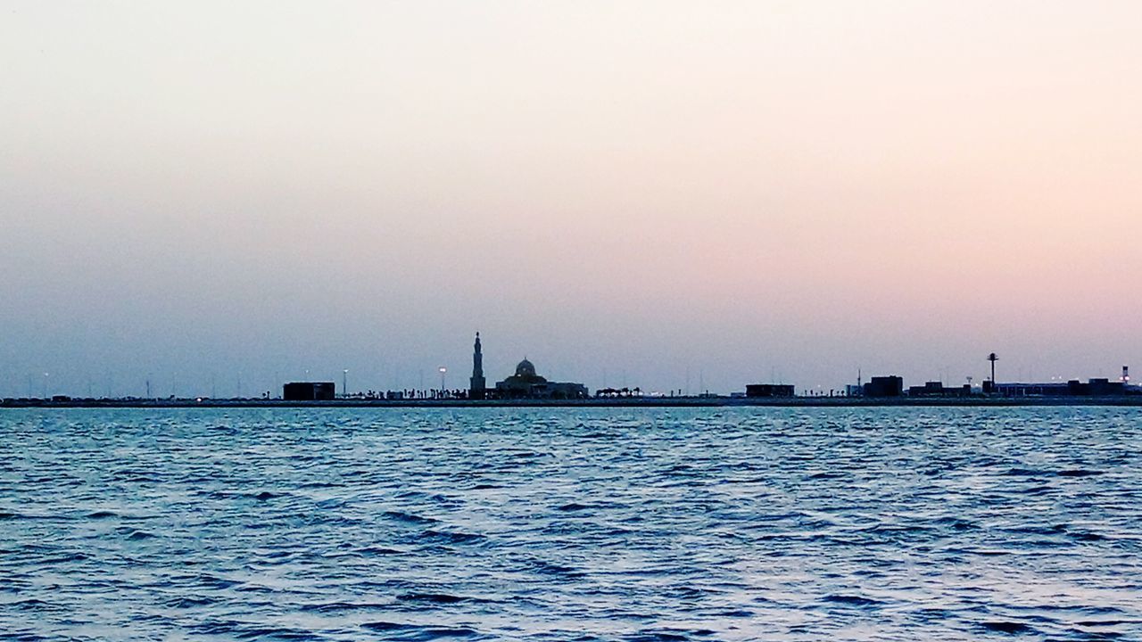 SCENIC VIEW OF SEA BY CITY AGAINST CLEAR SKY