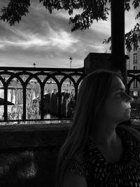 Rear view of woman standing by railing