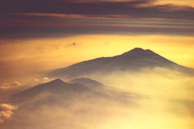 Scenic view of mountains against orange sky