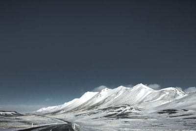 Scenic view of snowcapped mountains against clear sky