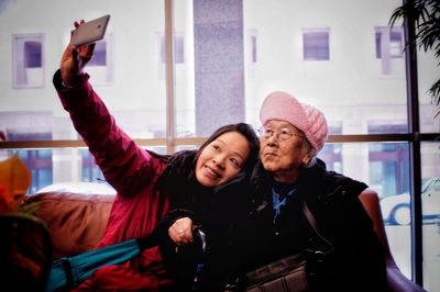 Smiling mid adult woman taking selfie with mother 