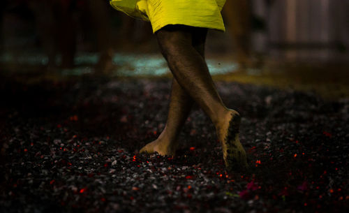 Low section of man running barefoot on hot coals