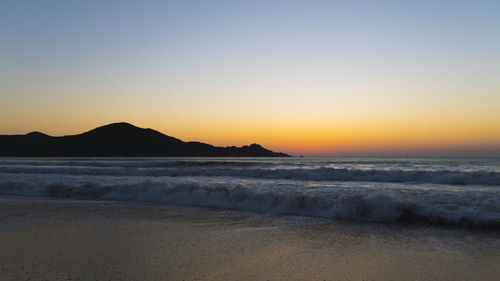 Scenic view of sea against clear sky during sunset