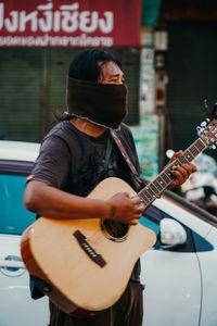 Man playing guitar in city