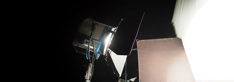 Low angle view of illuminated lighting equipment against clear sky