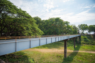 Bridge by trees against sky