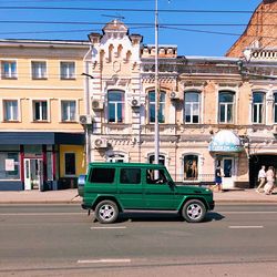 Car on street against buildings in city