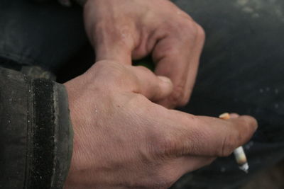 Close-up of hand holding cigarette