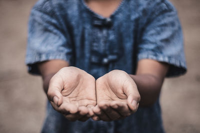 Midsection of boy with hands cupped