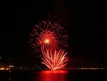 Firework display over river at night