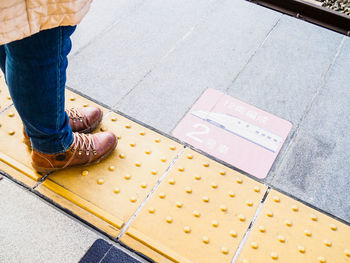 Low section of woman standing on tiled floor