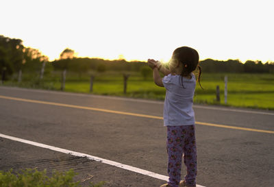 Rear view of woman walking on road