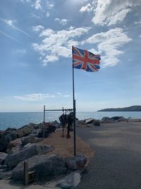 Flag on beach against sky