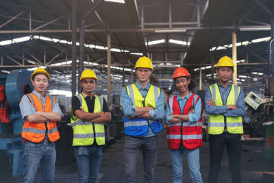 A group of industry workers and engineers of various races enjoy working in a heavy plant and stand 