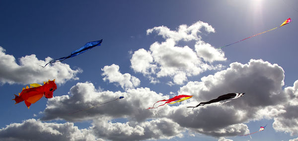 Low angle view of flags flying against sky