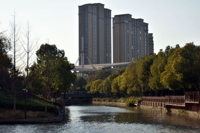 Scenic view of river by buildings against clear sky