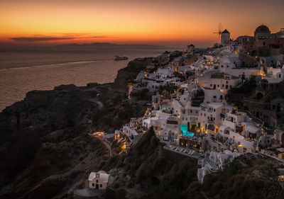 High angle view of oia village by sea at santorini during sunset