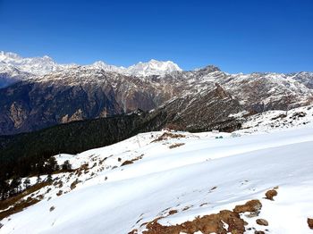 Scenic view of snowcapped mountains against clear blue sky