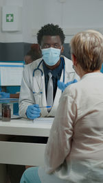 Portrait of female doctor examining patient in clinic