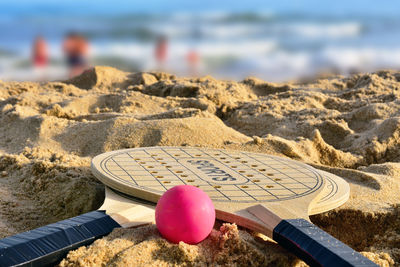Close-up of ball and rackets on sand
