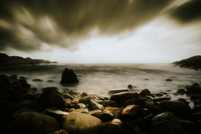 Rocks on sea shore against sky