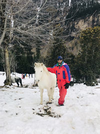 Man and horse on snow covered field