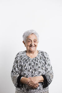 Portrait of happy senior woman in front of white background