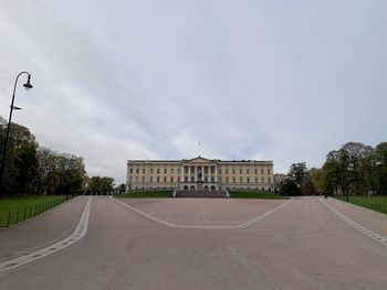 View of city street against cloudy sky