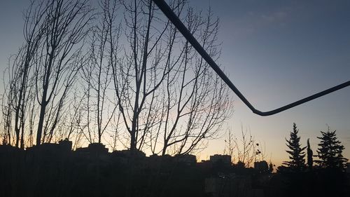 Low angle view of silhouette trees against clear sky