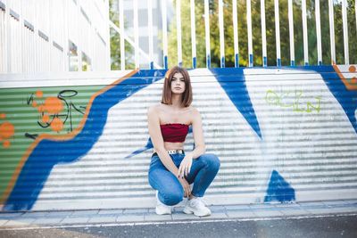 Portrait of woman sitting on floor in city